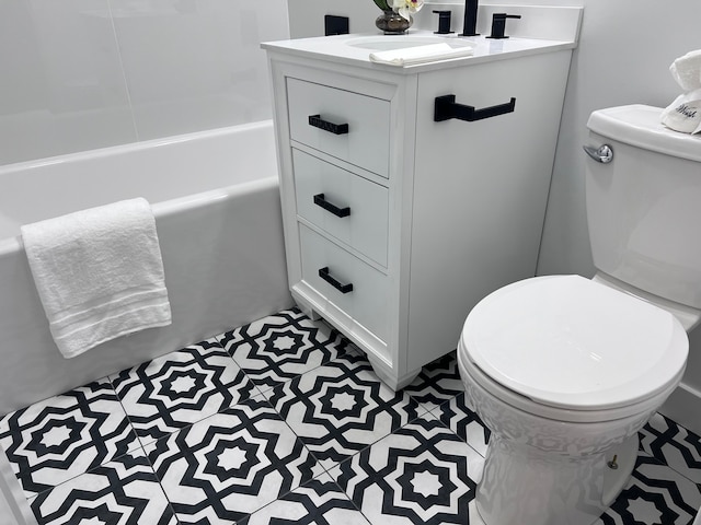 bathroom with vanity, a bathtub, and toilet