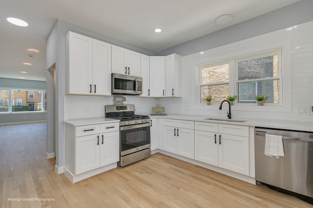 kitchen featuring sink, white cabinets, stainless steel appliances, and a healthy amount of sunlight