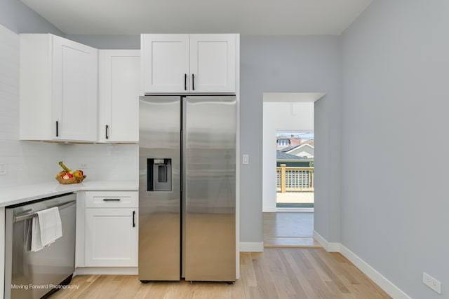 kitchen with white cabinetry, stainless steel appliances, decorative backsplash, and light wood-type flooring