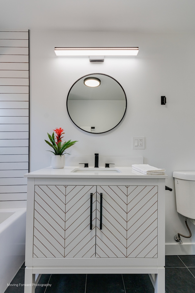 bathroom with vanity, toilet, tile patterned flooring, and a bathing tub