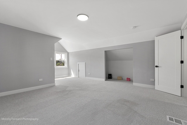 bonus room featuring lofted ceiling and light carpet