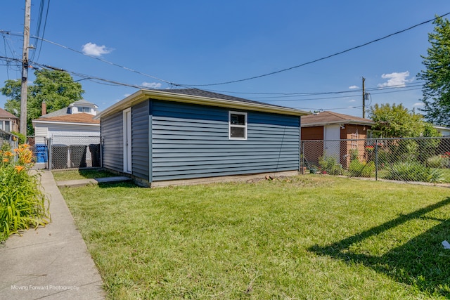 view of side of property featuring an outbuilding and a yard