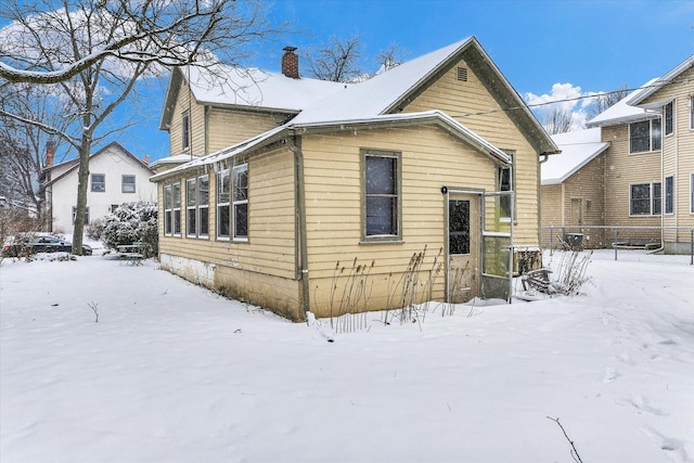 view of snow covered back of property