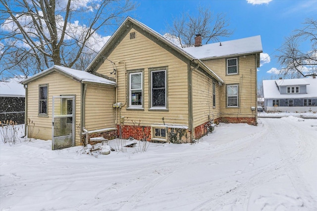 view of snow covered back of property