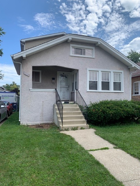 bungalow-style home featuring a front lawn