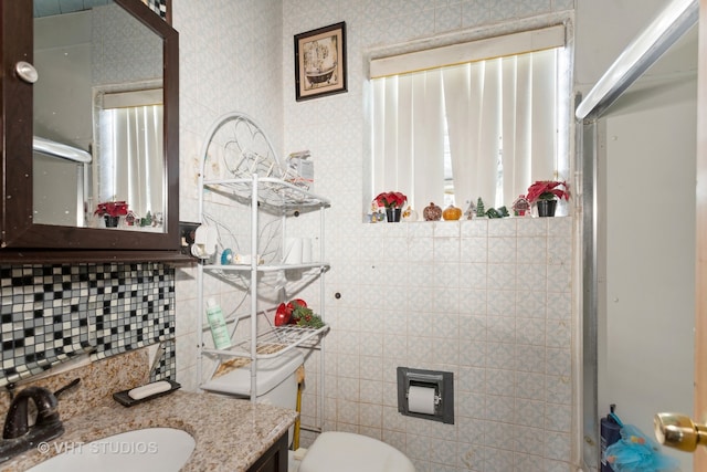 bathroom with vanity, toilet, tile walls, and an enclosed shower