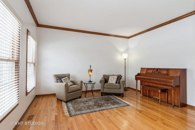 living area with crown molding and hardwood / wood-style flooring