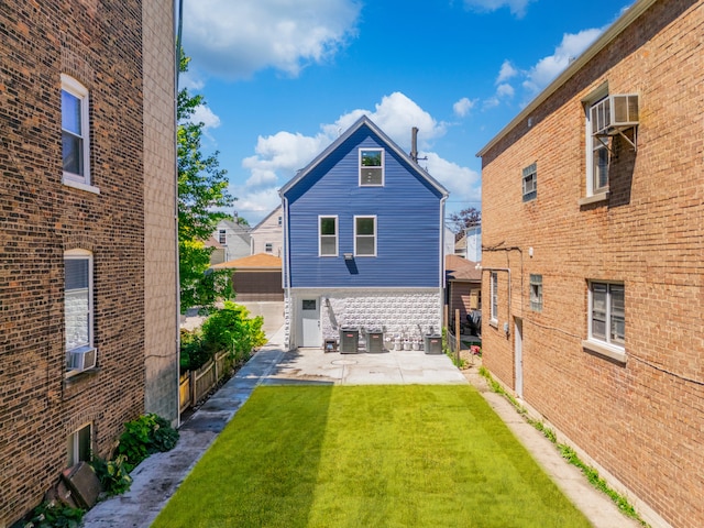 back of property featuring central air condition unit, a patio area, a yard, and cooling unit