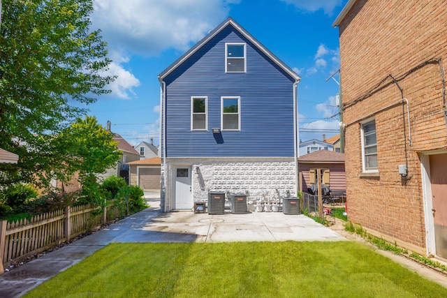 rear view of house featuring central air condition unit, a yard, and a garage