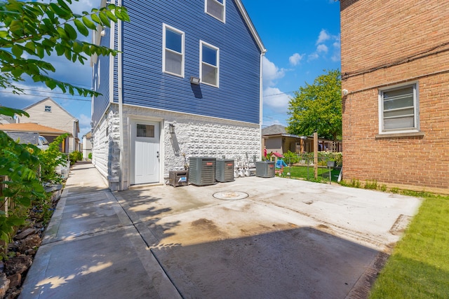 back of property with a patio and central AC