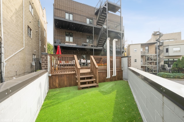 rear view of property with a balcony and a yard