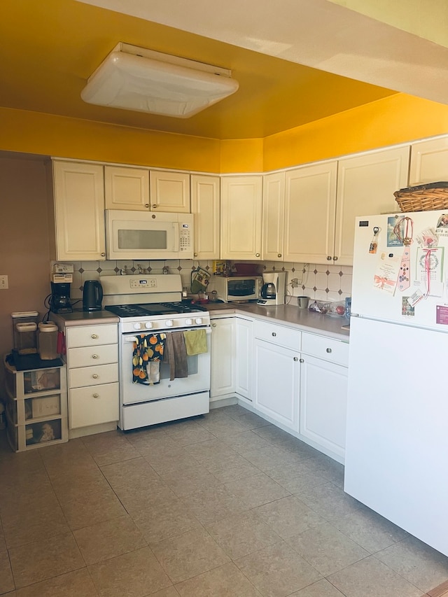 kitchen featuring light tile patterned floors, white cabinetry, white appliances, and tasteful backsplash