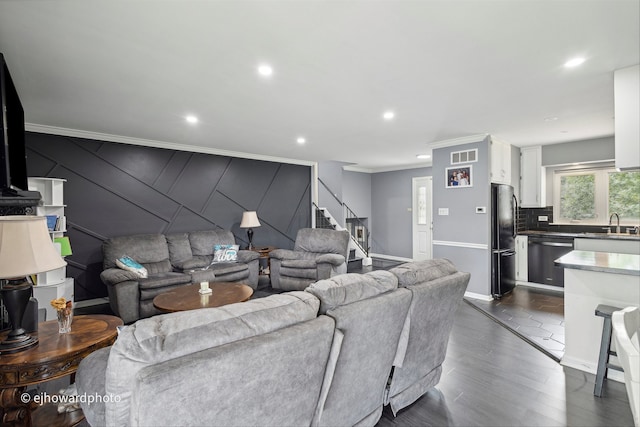 living room with crown molding, dark hardwood / wood-style floors, and sink