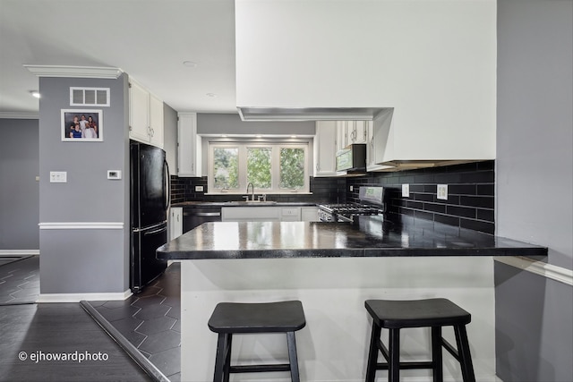 kitchen with appliances with stainless steel finishes, kitchen peninsula, white cabinetry, and sink