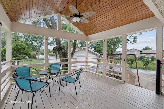 sunroom / solarium with lofted ceiling, wooden ceiling, and ceiling fan