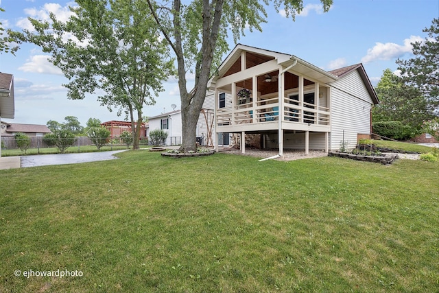 back of property with a yard and ceiling fan