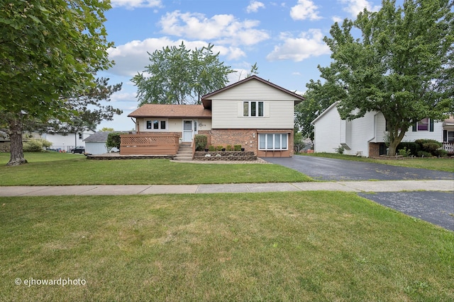 tri-level home featuring a front yard and a wooden deck