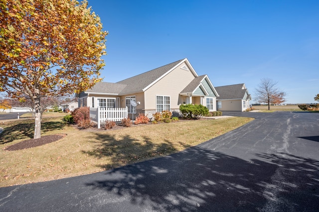 view of front of house with a front lawn, covered porch, and a garage