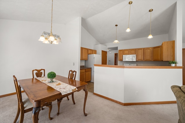 dining area featuring a notable chandelier, light carpet, and high vaulted ceiling