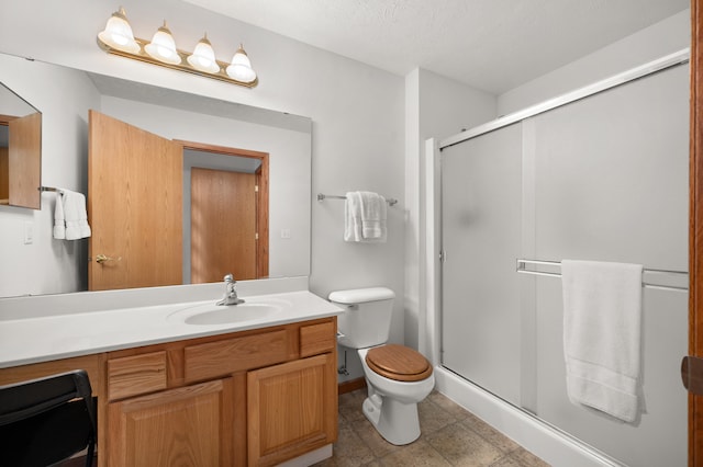 bathroom with a textured ceiling, walk in shower, toilet, vanity, and tile patterned flooring