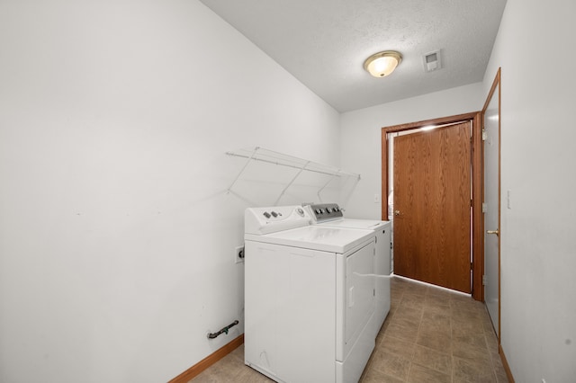 laundry room featuring independent washer and dryer and a textured ceiling