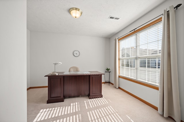 carpeted home office featuring a textured ceiling