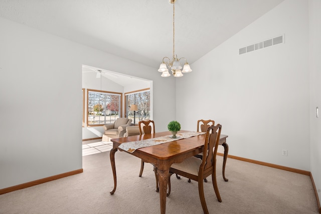 dining room with light carpet, ceiling fan with notable chandelier, and vaulted ceiling