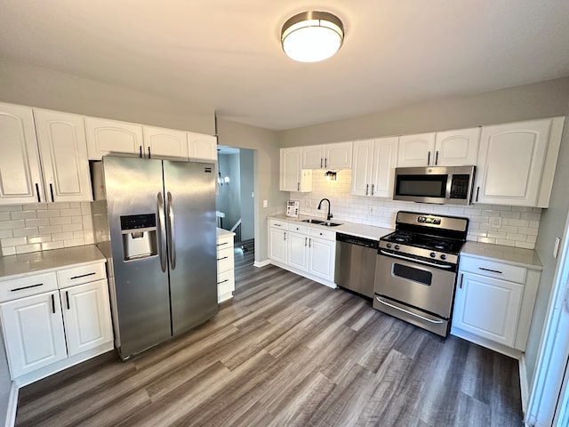 kitchen featuring dark hardwood / wood-style flooring, white cabinetry, sink, and appliances with stainless steel finishes