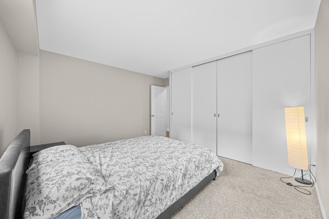 bedroom featuring light carpet and a closet