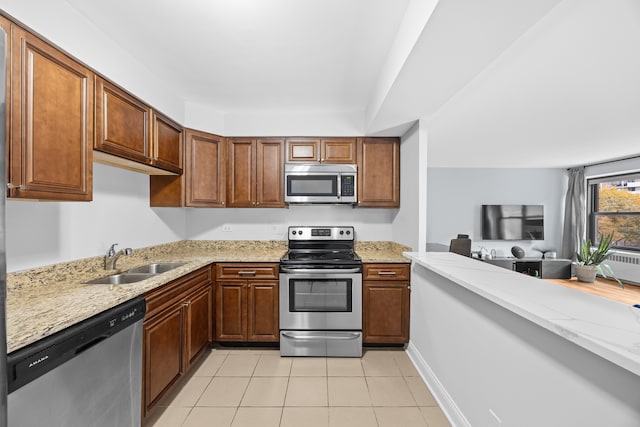 kitchen featuring sink, light stone countertops, stainless steel appliances, and light tile patterned floors