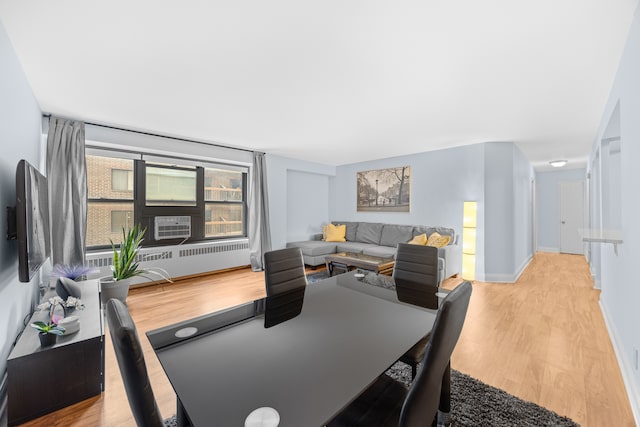 dining space featuring light hardwood / wood-style floors and radiator