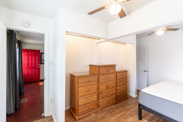 bedroom with hardwood / wood-style flooring, ceiling fan, and a closet