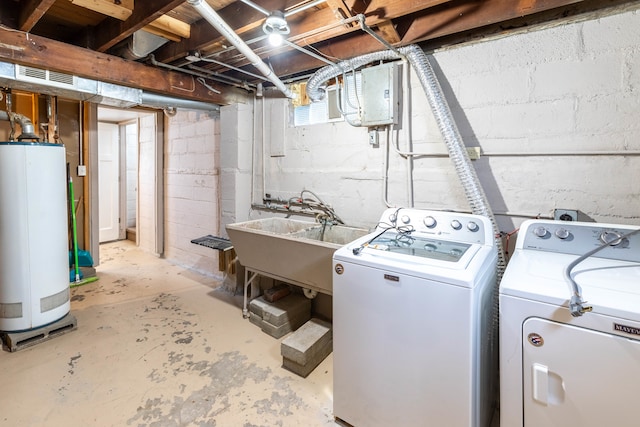 clothes washing area featuring water heater, sink, and washer and dryer