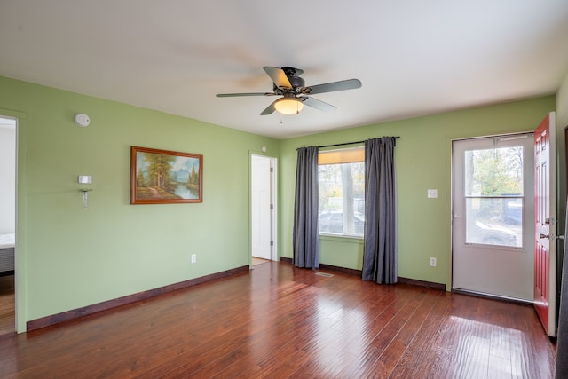 unfurnished room with dark wood-type flooring, ceiling fan, and a healthy amount of sunlight