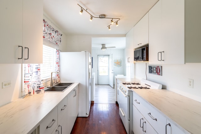 kitchen featuring dark hardwood / wood-style flooring, sink, white cabinets, white appliances, and ceiling fan