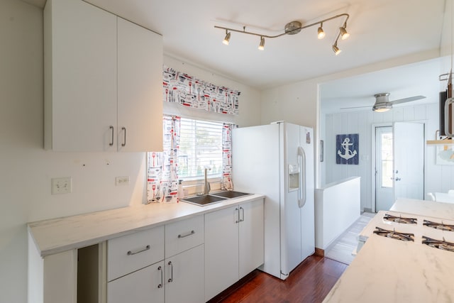 kitchen featuring white cabinetry, sink, ceiling fan, white appliances, and dark wood-type flooring