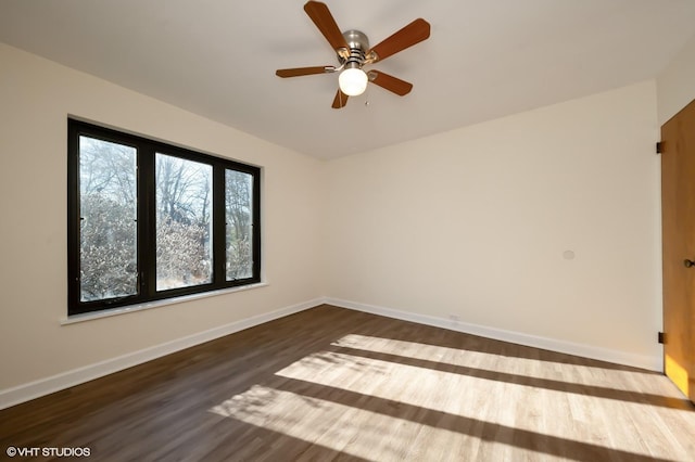 spare room with ceiling fan and dark wood-type flooring