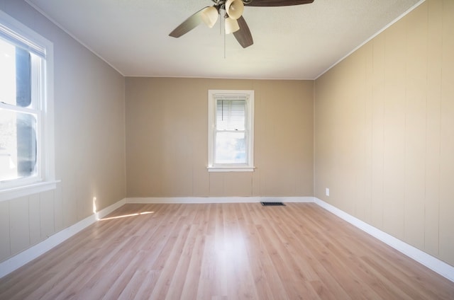 unfurnished room with light hardwood / wood-style floors, crown molding, a healthy amount of sunlight, and ceiling fan