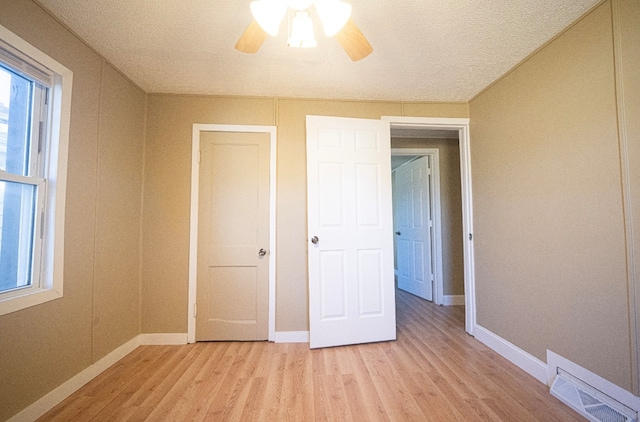 unfurnished bedroom featuring light hardwood / wood-style floors, a textured ceiling, and ceiling fan