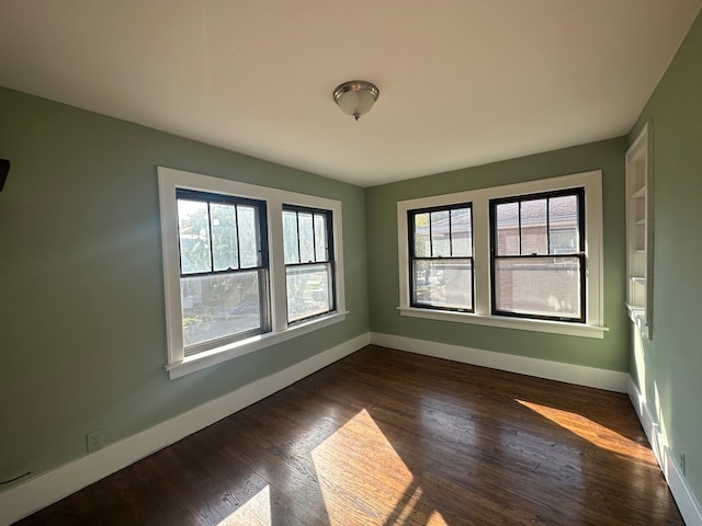 empty room with dark hardwood / wood-style flooring