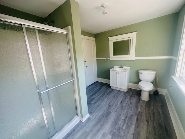 bathroom with vanity, hardwood / wood-style flooring, toilet, and an enclosed shower