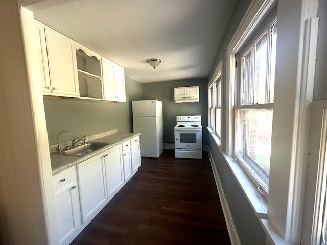 kitchen with white appliances, a healthy amount of sunlight, sink, and white cabinets