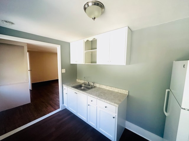 kitchen featuring sink, white cabinets, dark wood-type flooring, and white refrigerator