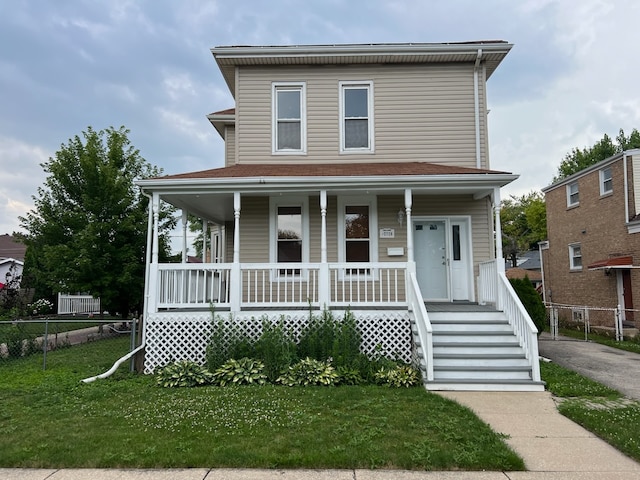 farmhouse inspired home with a front lawn and covered porch