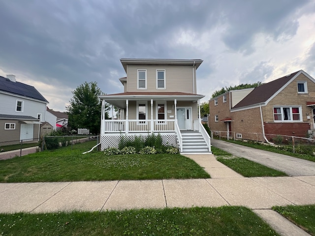 view of front of home with covered porch and a front lawn