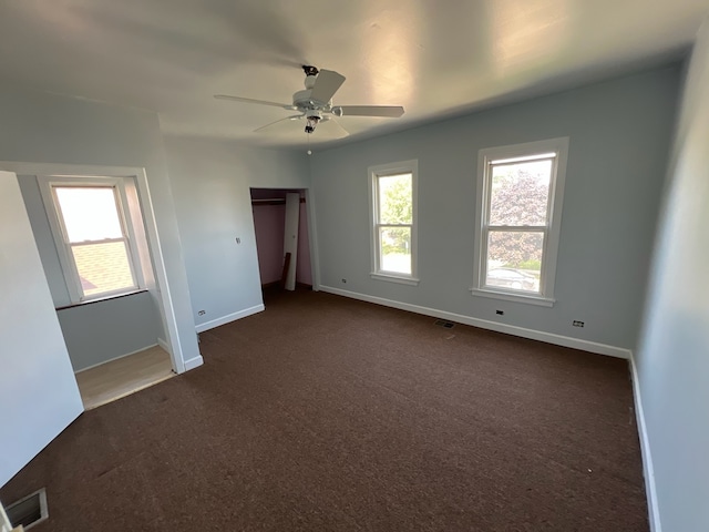 unfurnished bedroom featuring ceiling fan and dark carpet