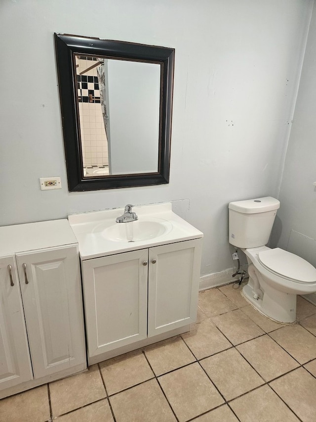 bathroom with toilet, vanity, and tile patterned floors