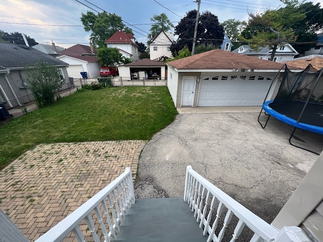 view of yard with a gazebo, a garage, and a trampoline