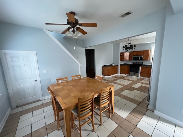 dining space with light tile patterned floors and ceiling fan with notable chandelier