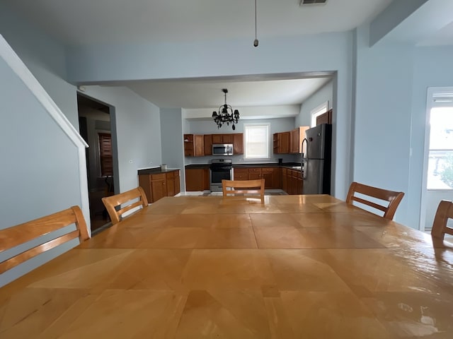 unfurnished dining area featuring a notable chandelier and a wealth of natural light